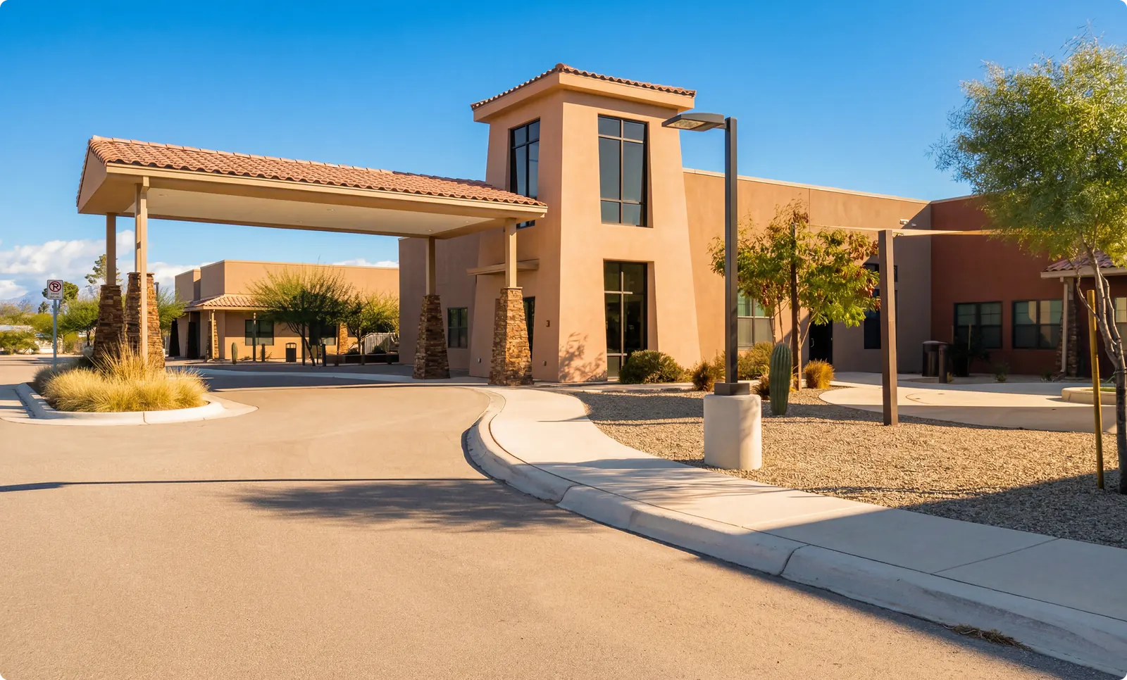 The covered drop-off entrance with tower feature and circular driveway
